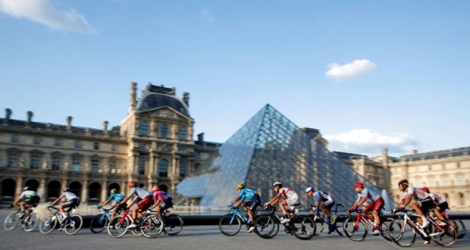Le peloton passant devant la pyramide du Louvres à Paris lors de la dernière étape du Tour de France 2019 entre Rambouillet et les Champs Elysées, le 28 juillet.