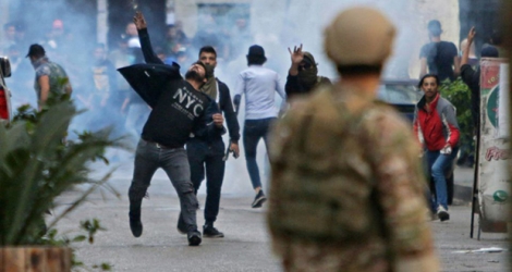 Des manifestants lancent des pierres sur l'armée à Tripoli, dans le nord du Liban, le 28 avril 2020.