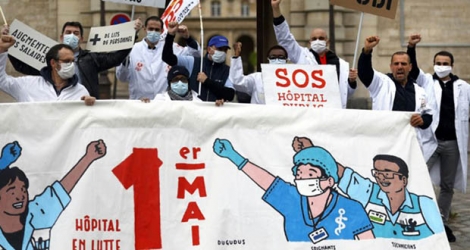 Des personnels soignants et membres du syndicat français CGT manifestent le 30 avril 2020 devant l'hôpital public parisien de la La Pitié Salpêtrière à la veille du 1er mai.