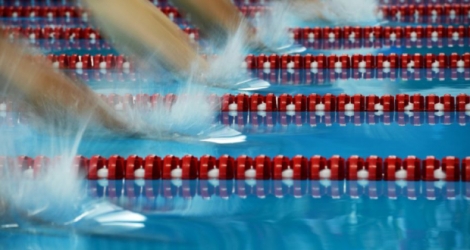Des nageurs plongent lors des séries du 400 m quatre bages des Jeux asiatiques 2018 le 22 août 2018 à Jakarta. Photo Martin BUREAU. AFP