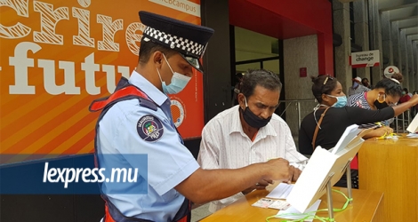 Un policier aide un «senior citizen» à remplir son formulaire de dépôt de chèque.