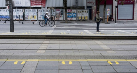 Un quai de tramway avec des marques jaunes peintes sur le sol pour que les gens gardent les règles de distanciation sociale, le 8 mai 2020 à Nantes.