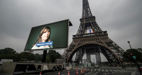 Hommage aux soignants et aux autres personnels mobilisés pendant la crise sanitaire sur un panneau géant à proximité de la Tour Eiffel à Paris le 10 mai 2020.