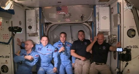 Image transmise par la Nasa de Robert Behnken (2e d) et Doug Hurley (d), à leur arrivée dans l'ISS, avec les autres astronautes de la station spatiale.
