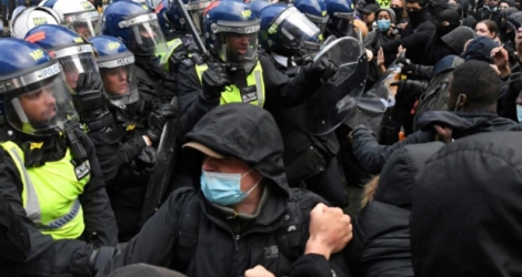 Des manifestants, certains équipés de masques, face à des policiers non loin de Downing Street le 6 juin 2020 lors d'une manifestation contre le racisme Photo DANIEL LEAL-OLIVAS. AFP