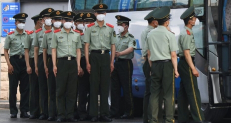 Des policiers chinois s'apprêtent à boucler les accès au marché Xinfadi de Pékin, le 13 juin 2020 Photo GREG BAKER. AFP