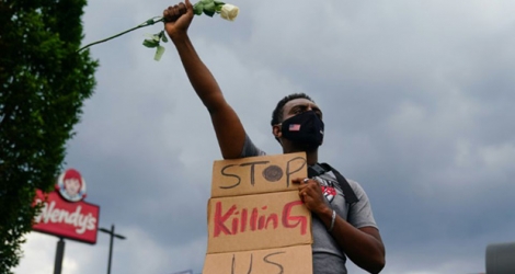 Un manifestant tient une pancarte implorant 