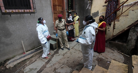 Des policiers et infirmiers sensibilisent au contrôle de santé gratuit dans des zones de pauvreté à Mumbai.