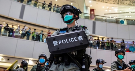 Un policier anti-émeute (C) dans un centre commercial hongkongais, le 6 juillet 2020.