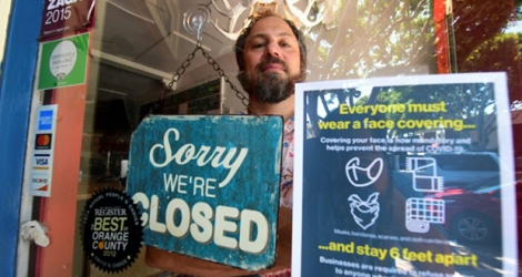 Gabriel Gordon derrière la porte de son restaurant qu'il doit fermer définitivement en raison de la pandémie, le 28 juillet 2020 à Seal Beach, en Californie.