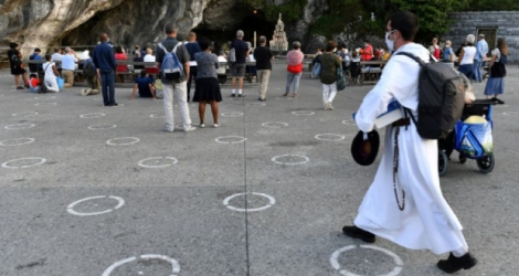 Des pèlerins prient devant la Grotte de Lourdes, le 14 août 2020 Photo GEORGES GOBET. AFP