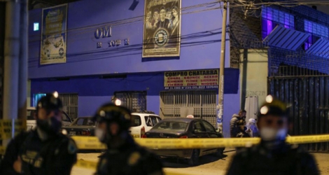 Des policiers montent la garde devant la discothèque où s'est produit une bousculade mortelle à Lima, le 23 août 2020.