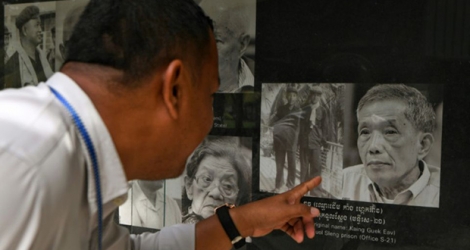 Un homme regarde le portrait du Douch ancien tortionnaire du régime des Khmers rouges, le 2 septembre 2020 au musée du génocide à Phnom Penh.