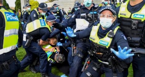 Des policiers amènent des manifestants au sol durant un rassemblement anti-confinement à Melbourne (Australie), le 5 septembre 2020 Photo William WEST. AFP