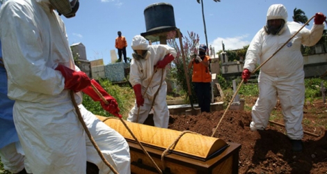 Des membres de la Protection civile mettent en terre le cercueil d'une victime du Covid-19 à San Cristobal, au Venezuela, le 1er septembre 2020.