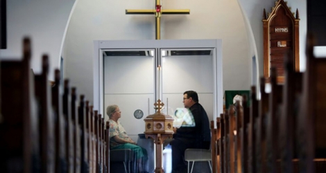 Le pasteur Joel Crouse (D) échange avec une fidèle à l'église luthérienne Saint John d'Ottawa, le 16 septembre 2020.