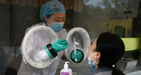 Une technicienne effectue un prélèvement dans un centre pratiquant des des tests rapides, le 27 septembre 2020 à Pékin.