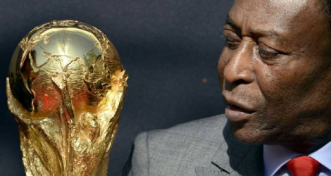 La légende brésilienne du football Pelé regarde le trophée de la Coupe du monde de la FIFA lors d'un événement à Paris, le 9 mars 2014 Photo FRANCK FIFE. AFP