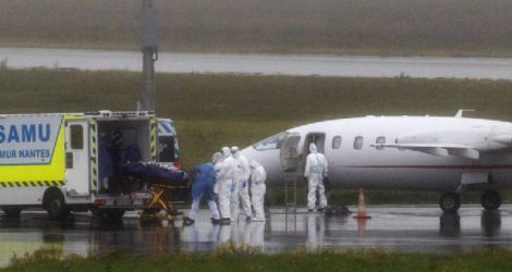 Du personnel médical prend en charge un malade du Covid-19 arrivé par avion médicalisé d'une région où les hopitaux sont débordés, à l'aéroport de Nantes-Atlantique, à Bouguenais, le 27 octobre 2020 Photo Loic VENANCE. AFP