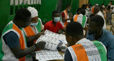 Des membres de la Commission électorale ivoirienne vérifient les listes de votants pendant le comptage des voix, le 31 octobre 2020 à Abidjan Photo Issouf SANOGO. AFP