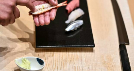 Le maître du sushi Toshiya Matsushita applique du wasabi frais à l'intérieur d'une crevette dans son restaurant de Tokyo, le 1er décembre 2020 Photo Charly TRIBALLEAU. AFP