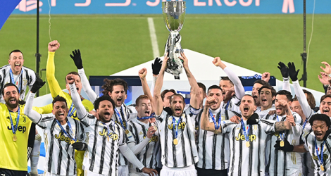 Le capitaine et défenseur de la Juventus Turin, Giorgio Chiellini, entouré de ses coéquipiers, soulève la Supercoupe d'Italie, après la victoire de son club face à Naples (2-0), le 20 janvier 2021 à Reggio Emilie.