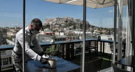 Un restaurateur masqué sur une terrasse de la capitale Athènes.