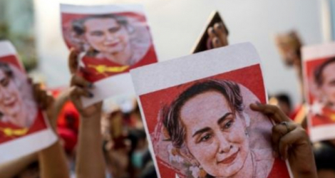 Des portraits d'Aung San Suu Kyi sont brandis par des manifestants devant l'ambassade de Birmanie à Bangkok, le 7 février 2021 © AFP, Jack TAYLOR