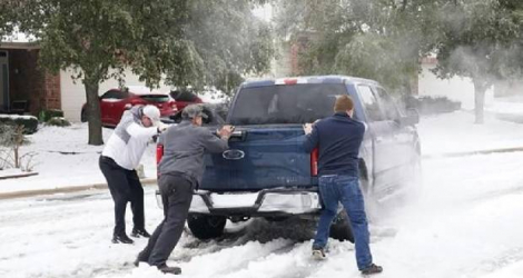 Des habitants tentent de dégager un camion de la neige, dans la ville de Round Rock au Texas, le 17 février 2021  afp.com - Suzanne CORDEIRO