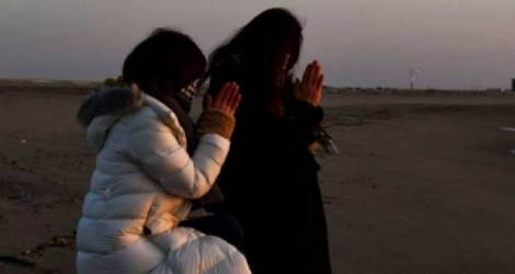 Prières à la mémoire des victimes du séisme et du tsunami de 2011 au lever du soleil à Sendai, dans le nord-est du Japon, le 11 mars 2021 AFP - KAZUHIRO NOGI