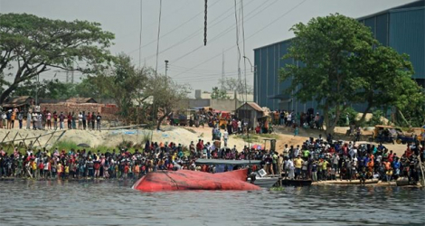 Des proches des victimes du naufrage d'un ferry au Bangladesh et des badauds regardent les opérations de secours sur la rivière Shitalakshya le 5 avril 2021. afp.com - Munir Uz zaman