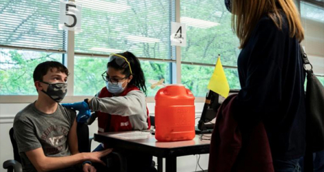 Un adolescent se fait vacciner contre le Covid-19 à Fairfax (Etats-Unis) le 13 mai 2021. afp.com - ANDREW CABALLERO-REYNOLDS