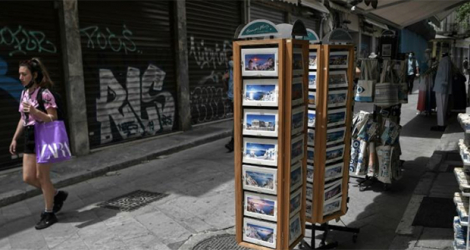 Une femme passe près d'une boutique de souvenirs dans le centre d'Athènes, le 12 mai 2021. afp.com - Louisa GOULIAMAKI