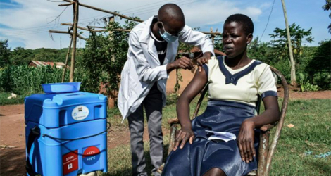 Un infirmier administre le vaccin Oxford/AstraZeneca contre le Covid-19 à une femme, à Siaya, au Kenya, le 18 mai 2021. afp.com - Brian ONGORO