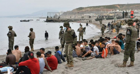 Des soldats espagnols surveillent des migrants arrivés à la nage depuis le Maroc sur l'enclave espagnole de Ceuta, le 18 mai 2021. afp.com - Antonio Sempere