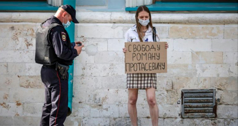 Une jeune femme brandit une pancarte «Liberté pour Roman Protassevitch» devant l'ambassade du Bélarus à Moscou le 25 mai 2021. afp.com - Dimitar DILKOFF