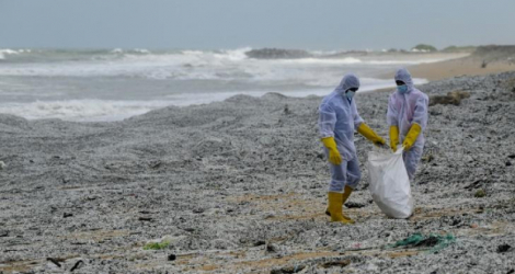 Des soldats de la Marine sri-lankaise nettoient une plage polluée par des tonnes de granulés plastiques provenant d'un porte-conteneurs en feu depuis neuf jours au large de Colombo le 28 mai 2021 afp.com - Ishara S. KODIKARA