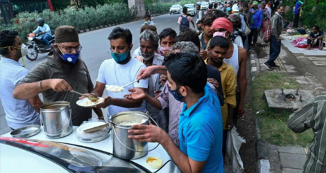 Des Indiens sans domicile fixe, notamment des travailleurs journaliers, font la queue pour une distribution de nourriture à New Delhi le 20 mai 2021. afp.com - Prakash SINGH