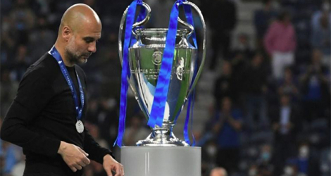 L'entraîneur espagnol de Manchester City, Pep Guardiola, passe devant le trophée de la Ligue des Champions, après la défaite (1-0) de son équipe en finale face à Chelsea, le 29 mai 2021 au stade Dragao à Porto. afp.com - PIERRE-PHILIPPE MARCOU