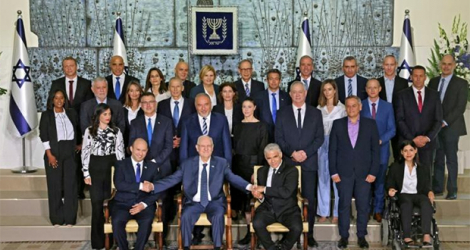 Le nouveau gouvernement israélien avec le président Reuvin Rivlin (c), le Premier ministre Naftali Bennett (g) et le ministre des Affaires étrangères Yaïr Lapid (d), à Jérusalem le 14 juin 2021.