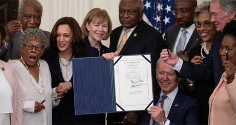 Le président américain Joe Biden montre le texte signé d'une loi établissant un nouveau jour férié fédéral, le «Juneteenth» pour commémorer l'émancipation des derniers esclaves au Texas il y a 156 ans, le 17 juin 2021 à Washington.