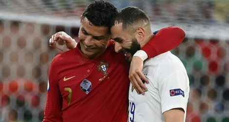 Les attaquants Cristiano Ronaldo et Karim Benzema discutent à la fin de la 1ère mi-temps entre le Portugal et la France, lors de la 3e journée du groupe F à l'Euro 2020, le 23 juin 2021 à Budapest.
