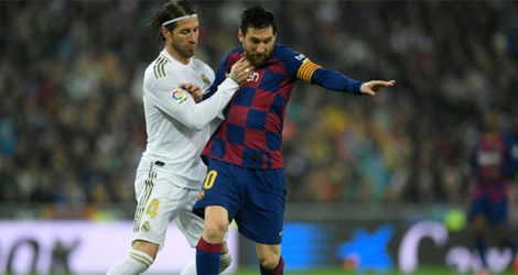 L'attaquant argentin de Barcelone, Lionel Messi, aux prises avec le défenseur du Real Madrid, Sergio Ramos, lors de leur match de Liga, le 1er mars 2020 au stade Santiago Bernabeu à Madrid.