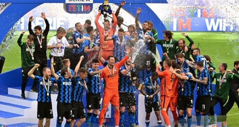 Les joueurs de l'Inter Milan fêtent leur titre de champions d'Italie autour du trophée du Scudetto, après leur dernier match de Serie A contre Udinese, le 23 mai 2021 au Stade de San Siro.