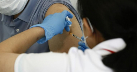 Un Japonais recevant une dose du vaccin Moderna contre le Covid-19, le 25 juin 2021 à Tokyo.