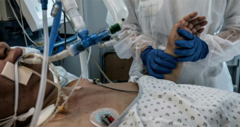 Une infirmière s'occupe d'un patient infecté par le Covid-19 dans le service de soins intensifs de l'hôpital Lyon-Sud à Pierre-Benite, le 8 septembre 2021.