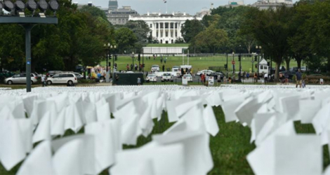 La Maison Blanche est vue au travers d'un champ de drapeaux blancs, sur le Mall à Washinton, symbolisant les morts du Covid-19 aux Etats-Unis, le 16 septembre 2021.