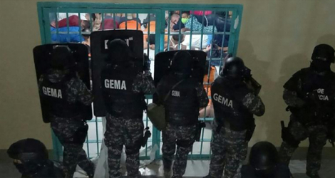 Photo diffusée par la police équatorienne le 30 septembre 2021 de policiers intervenant à la prison de Guayaquil, en proie à des affrontements entre prisonniers.