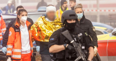 Des policiers et des secouristes emmènent un homme arrêté, le 6 novembre 2021 à Seubersdorf, dans le sud de l'Allemagne, après une attaque dans un train qui a fait plusieurs blessés.
