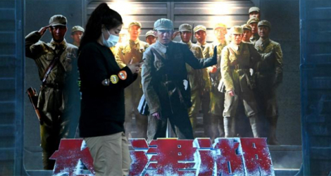 Une femme passe devant une affiche du film «La bataille du lac Changjin» dans un centre commercial de Pékin, le 11 octobre 2021.